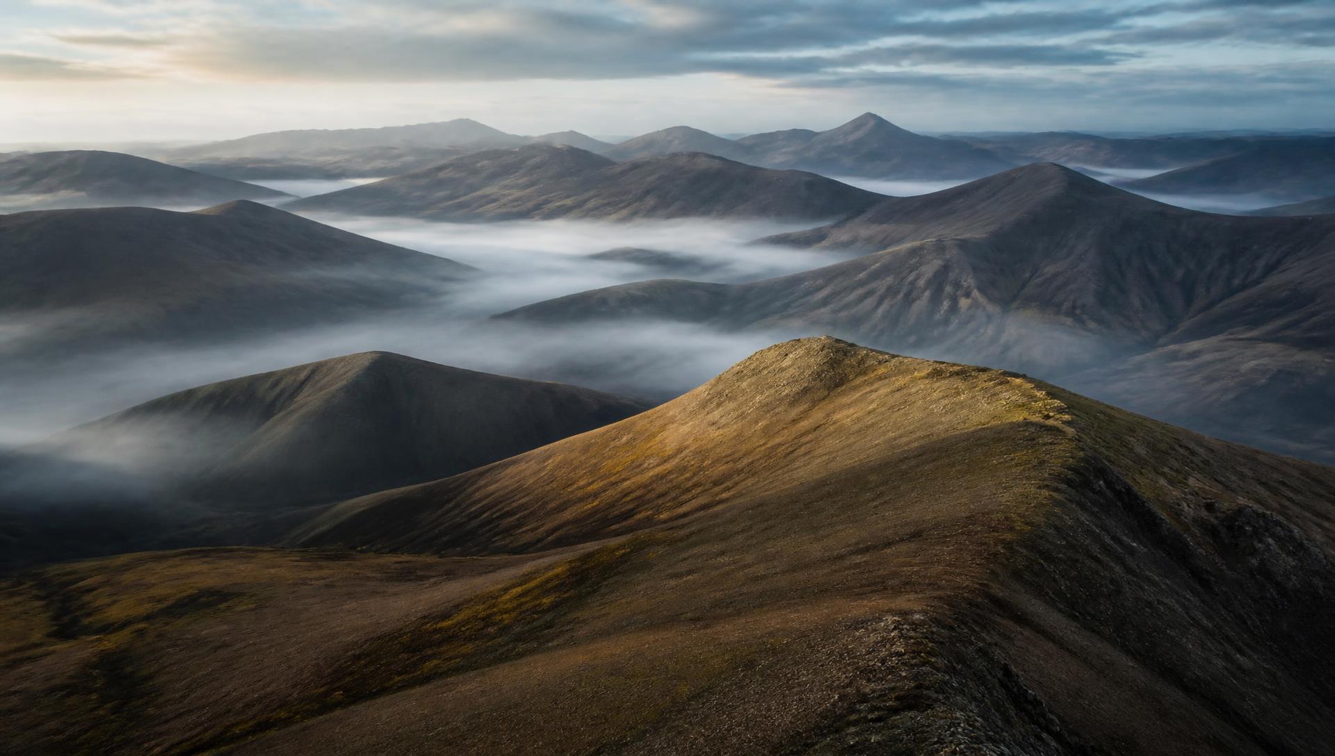 Ridgelines and valley cloud in northern gold exploration country at first light